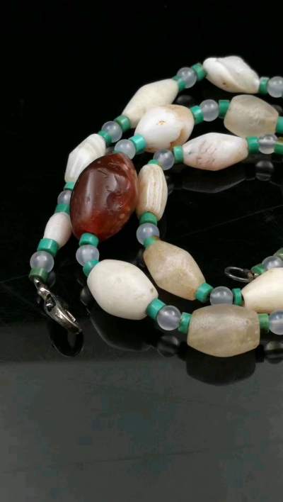 高古橄榄型缠丝玛瑙项饰
由一颗酒红色主珠,和两边