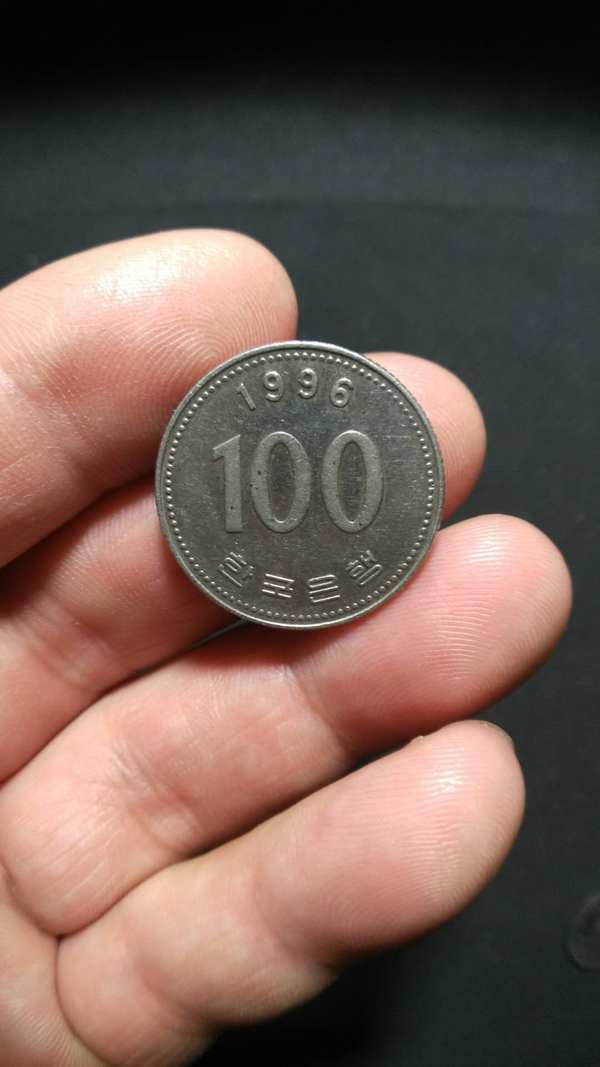 韩币官员头像,100元,灯光下